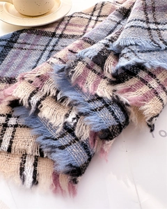 Close-up of the soft cashmere-like plaid texture and fringe details on the scarf