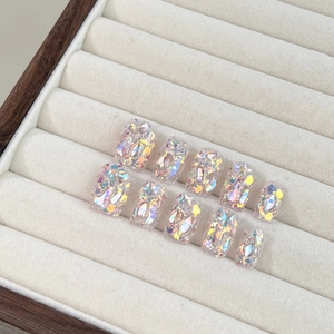 Short square press-on nails with holographic glitter flakes on a transparent base