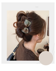 Close-up of a vintage brown flocking bow hair claw with plaid pattern and metal chain