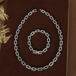 Polished silver rectangular link necklace and bracelet set on brown velvet display