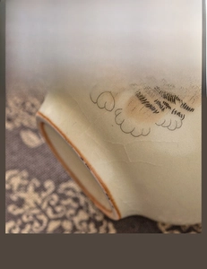 Macro detail of hand-painted cat paw on ceramic Ru kiln teacup with stable matte base