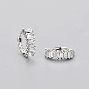 Detailed close-up of silver earrings with rectangular zircon stones in a sleek hoop style