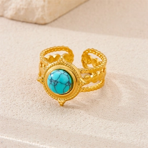 Detail of an 18k gold plated stainless steel ring with a round turquoise stone insert