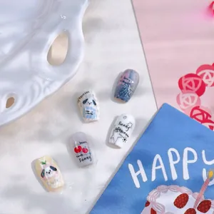 Detail of hand-painted puppy nail art stickers with cherry and bow patterns