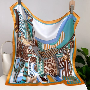 Detailed view of square silk scarf with horse harness patterns and orange border