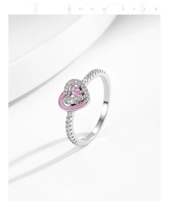 Detail of s925 silver ring featuring pink enamel heart and pear-shaped gemstone