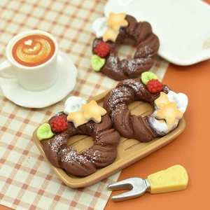 Macro shot of miniature resin Christmas wreath donuts with star cookies on a tray