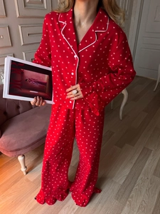 Detail of red pajama set featuring white heart prints and delicate ruffle hem on trousers