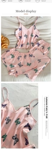 Detail view of pink satin pajama set with colorful butterfly prints and spaghetti straps