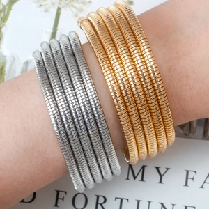 Minimalist layered spring bracelets in gold and silver finish worn by a model