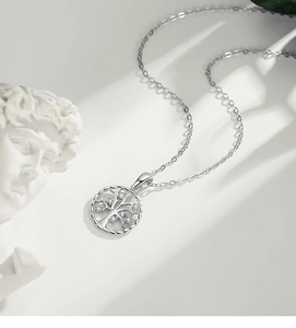 Macro shot of a S925 silver tree of life pendant with white zircon stones on white surface