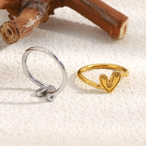 Bagues cœur minimalistes en or et argent sur un fond à texture naturelle élégant