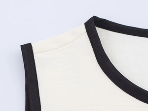 Close-up of contrast black binding on cream white crew neck crepe top for women