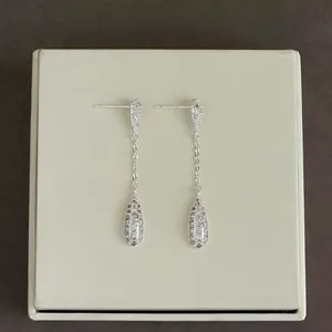 Macro detail of silver drop earrings with shimmering cubic zirconia and link chains
