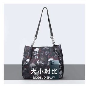 Gothic tote bag with skull and rose print next to a phone for size comparison