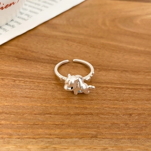Macro shot of silver horse ring with matte finish on a natural textured wooden desk