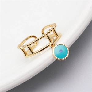 Adjustable gold evil eye open ring with blue enamel charm on white ceramic surface