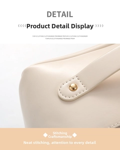 Detail of the stitching and golden rivet on the beige PU leather makeup bag handle