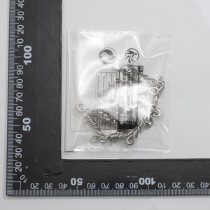 Macro view of silver barbed wire chain necklace with ruler for size measurement