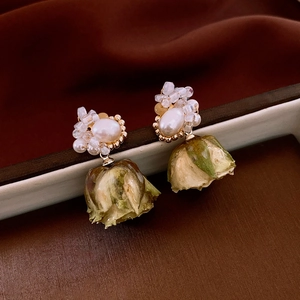 Detail of 18k gold plated earrings featuring pearl studs and realistic dried flower buds