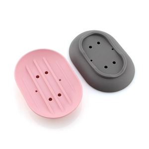 Detail view of pink and grey silicone soap dishes with multi-hole drainage system