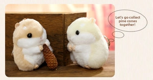 Close-up of plush hamster keychains holding pine cones on a rustic wooden table