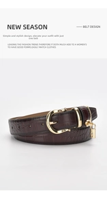 Detail of dark brown crocodile pattern leather belt with gold horseshoe buckle and padlock
