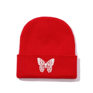 Red knit beanie featuring white butterfly embroidery and classic ribbed cuff design