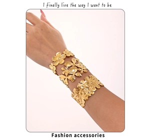 Macro shot of three gold-plated stainless steel bangles with floral patterns