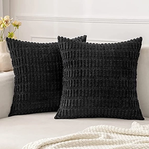 Close-up of black corduroy pillow covers with striped texture on white sofa