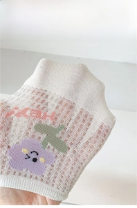 Détail de chaussettes invisibles en maille blanche avec motif tulipe et texture de fil torsadé
