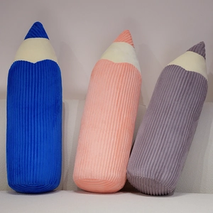 Soft creative pencil plush pillows in blue, orange, and purple corduroy on a sofa