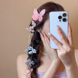 Close-up of fabric butterfly hair clip with pearl tassels on a braided hairstyle