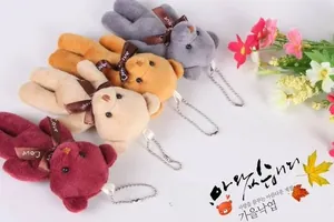 Detailed view of plush teddy bear charms in four colors with Love ribbons and metal chains