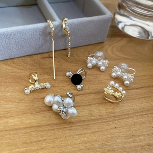 Mise à plat de boucles d'oreilles perles et zircon avec manchettes sur bois