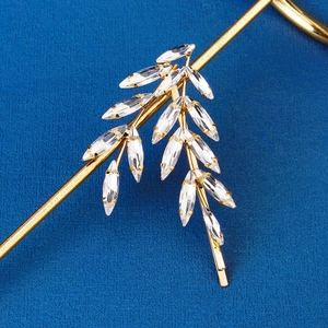 Macro view of crystal leaf bridal hair clip with gold alloy base and rhinestone detail