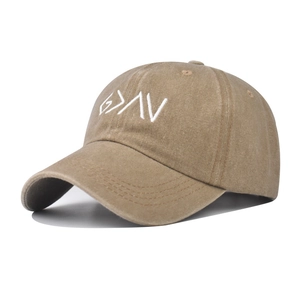 Close-up of white embroidery on a washed brown cotton baseball cap with vintage texture