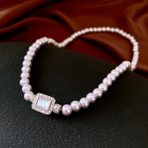 Detailed shot of vintage pearl necklace with a zircon-encrusted rectangular pendant