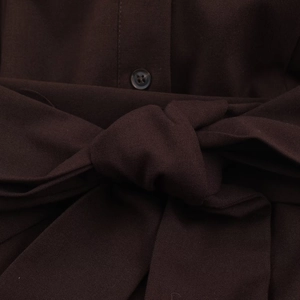 Detail view of dark brown shirt dress showing buttons and matching waist tie belt