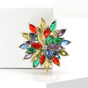 Detail shot of a sparkling crystal flower brooch with colorful stones on a golden base