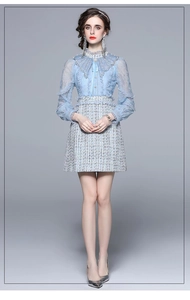 Detail of light blue tweed dress with intricate beadwork and elegant lace embroidery
