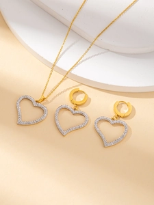 Dettaglio di un set di gioielli a cuore cavo con strass e placcatura in oro giallo