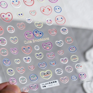Macro view of 3D embossed colorful smiley face nail stickers with reflective heart patterns