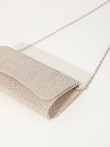 Detail of champagne gold glitter party clutch showing shimmering texture and silver chain
