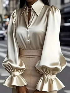 Dettaglio elegante camicia in raso champagne con maniche a sbuffo e colletto a punta