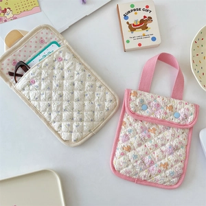 Detailed view of quilted cotton wristlet bags with floral and cartoon dog patterns