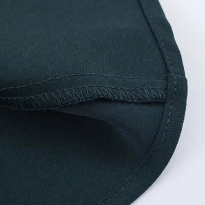 Dettaglio delle cuciture di qualità e della trama del tessuto twill su un abito midi verde