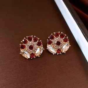 Detail of vintage gold flower earring with red crystals and marquise gems in macro view