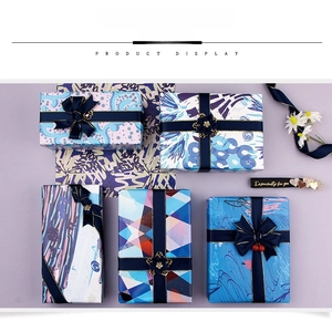 Detail view of five luxury gift boxes with abstract patterns and decorative navy ribbons