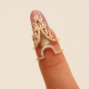 Macro shot of gold-plated fingernail ring with marquise-cut cubic zirconia in crown design